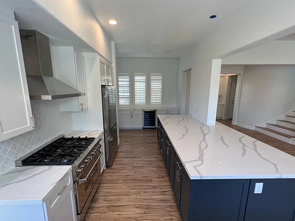 a kitchen with navy blue island cabinets and quartz countertop