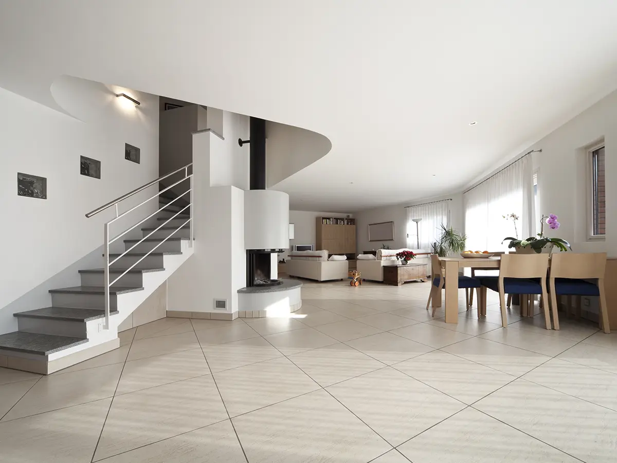 A living space with tile flooring and an open space kitchen