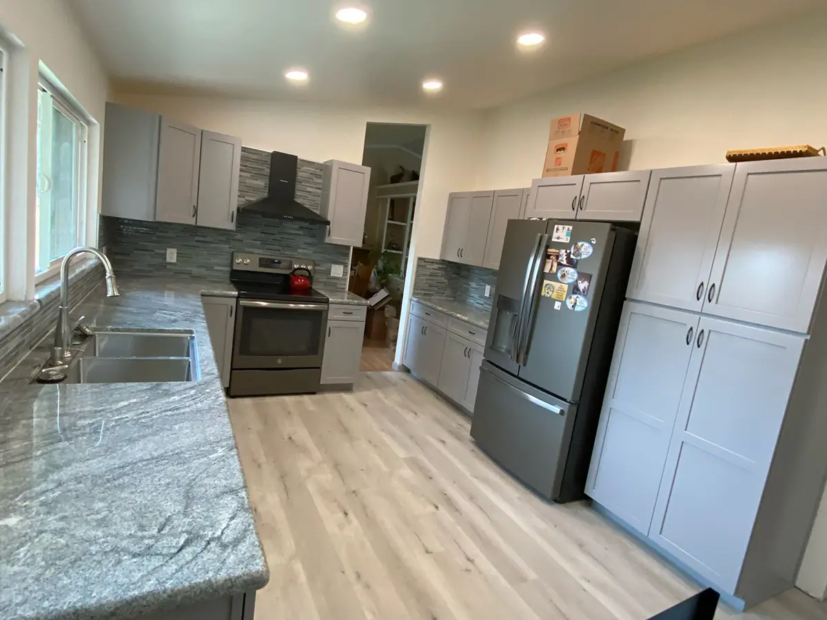 A new kitchen with granite countertop and gray kitchen cabinets