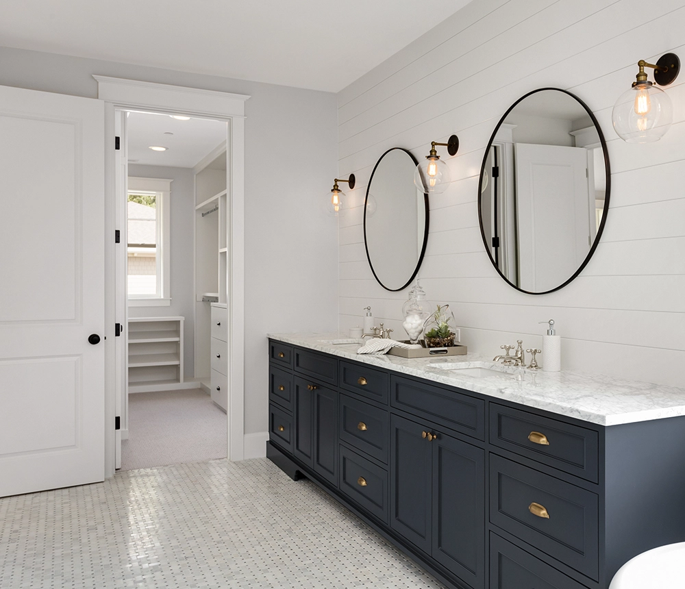 A navy blue vanity with round mirrors