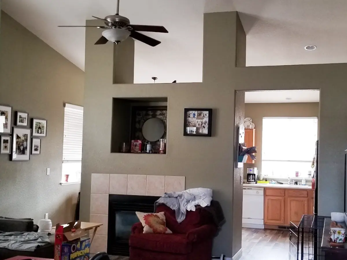 Old living room with large wall dividing the kitchen and living room area