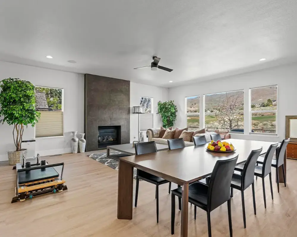 A large living room with a dining table, a couch, and a fireplace