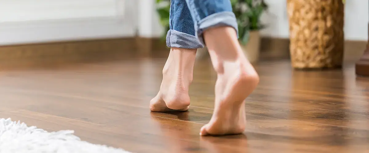 Bare feet walking on newly finished hardwood floor installation in Reno, showcasing a smooth and polished wooden surface.