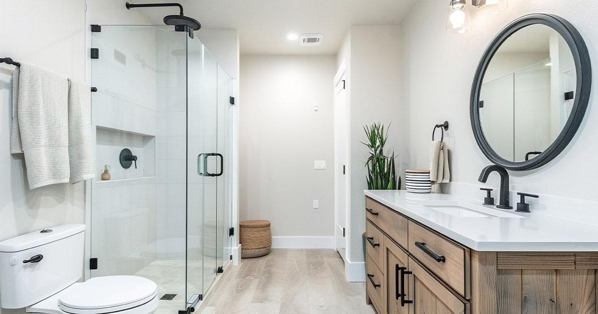 Contemporary bathroom with glass-enclosed, frameless shower doors, wood vanity, and black fixtures - modern bathroom design and renovation.