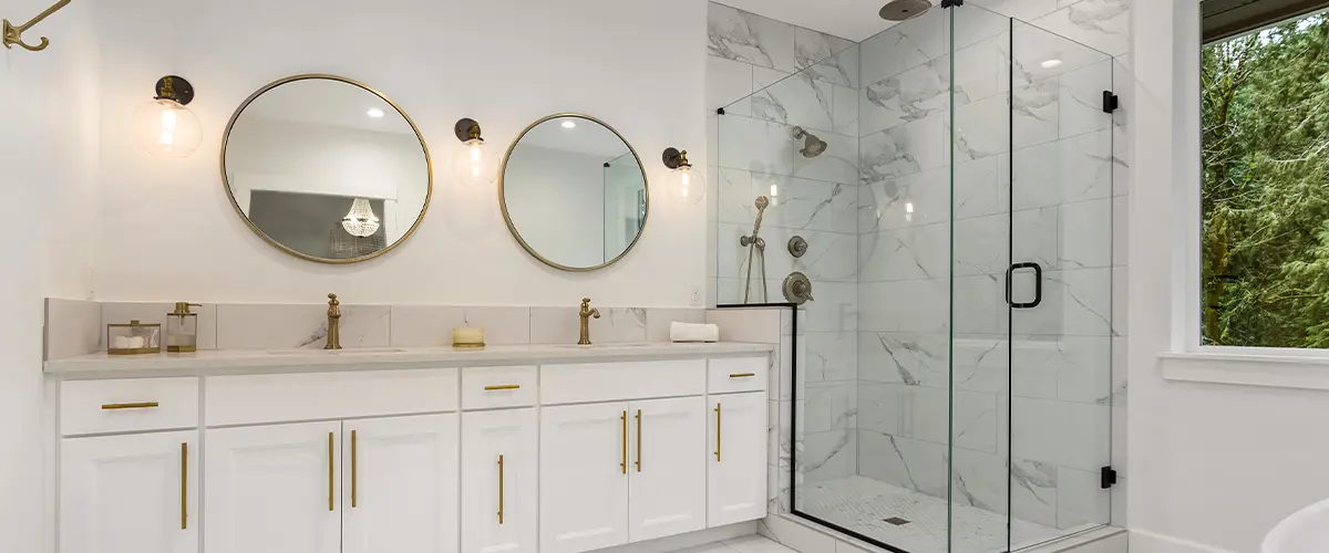 Luxurious modern bathroom with white cabinets, double vanity, and glass-enclosed shower featuring marble tile - bathroom renovation design.