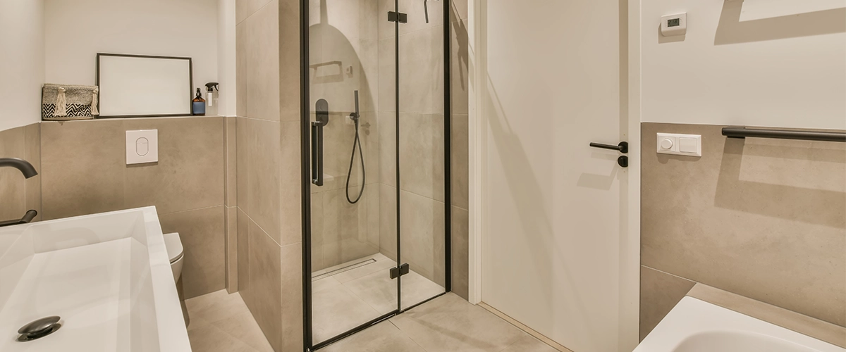 a modern bathroom with shower, toilet and bathtub in the background